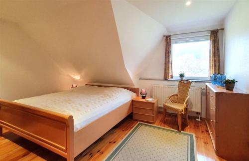 ein Schlafzimmer mit einem Bett, einem Stuhl und einem Fenster in der Unterkunft Lilie in Mirow