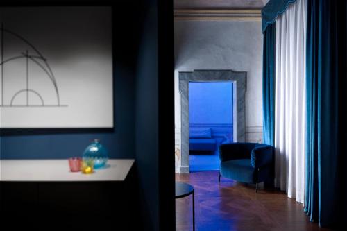 Palazzo Giusti Suites and Spa في أوربينو: غرفة معيشة مع طاولة بيضاء وغرفة زرقاء