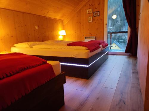 two beds in a wooden room with a window at Panorama-Chalet Alpenglöckchen in Stadl an der Mur