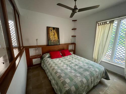 um quarto com uma cama com duas almofadas vermelhas em Yoga House em Torre de Benagalbón