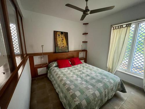 a bedroom with a bed with two red pillows at Yoga House in Torre de Benagalbón