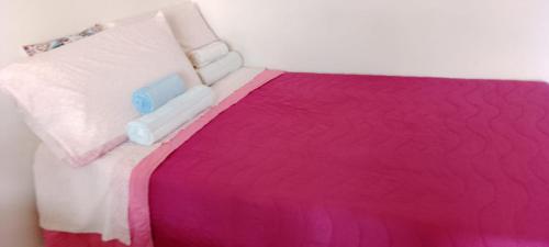 un letto con piumone rosa e bianco di Casa vacanza G.S. Holiday a Catania