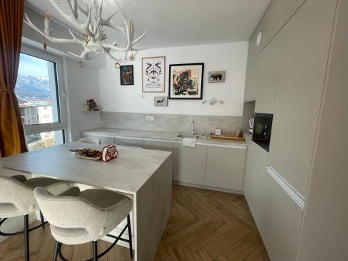 a kitchen with a table and chairs and a chandelier at OHDA APARTMENT in Sinaia