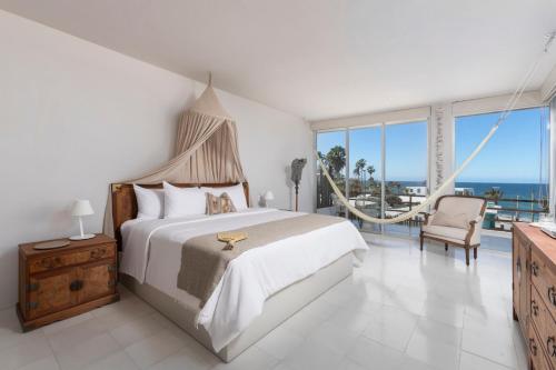 a bedroom with a bed and a balcony with the ocean at Hotel Boutique Casa Lulu in Mazatlán