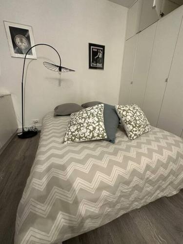 a bed with two pillows on it in a room at Mytripinparis - Sablons in Neuilly-sur-Seine