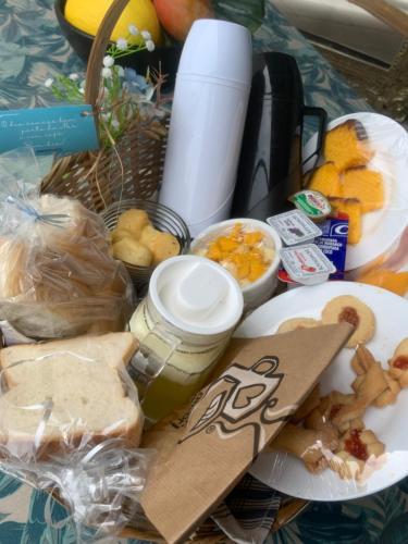 una mesa con una cesta de comida y un plato de comida en Pousada Bravo en Balneário Camboriú