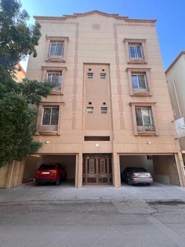a building with two cars parked in front of it at Ban Luxury Apartments in Al Khobar