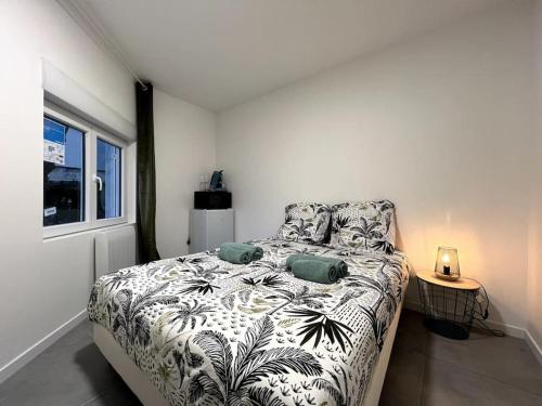 Schlafzimmer mit einem Bett mit einer schwarzen und weißen Bettdecke in der Unterkunft iota - studio 2 pers / centre - proche hôpital in Montereau-faut-Yonne