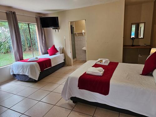 a hotel room with two beds and a bathroom at Leribisi Lodge in Tierpoort