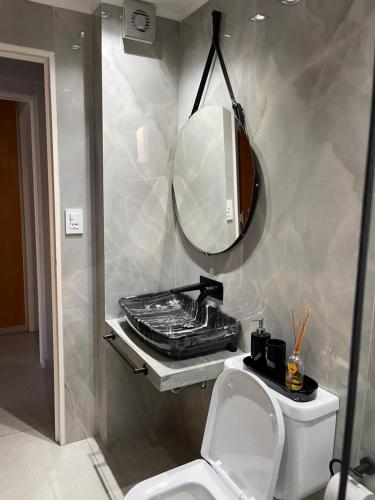 a bathroom with a toilet and a mirror at Departamento Fabuloso 3 in Rosario