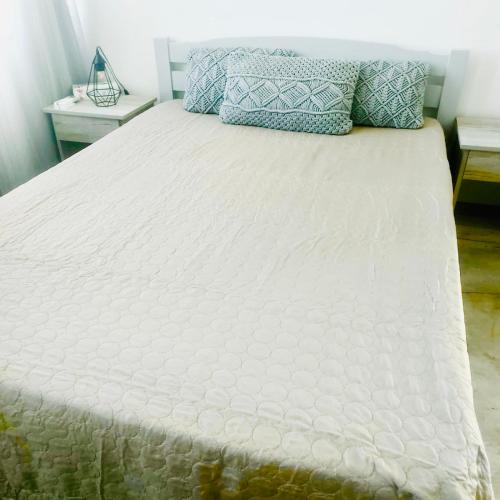 a large white bed with two pillows on it at Villa SempreViva in Trou d'Eau Douce