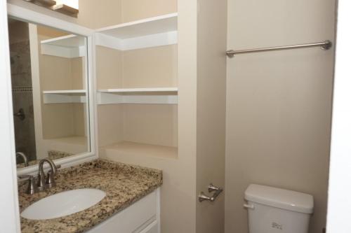 a bathroom with a sink and a mirror and a toilet at Venture Out 476 Marlin Dr Comes WITH GOLF CART in Panama City Beach
