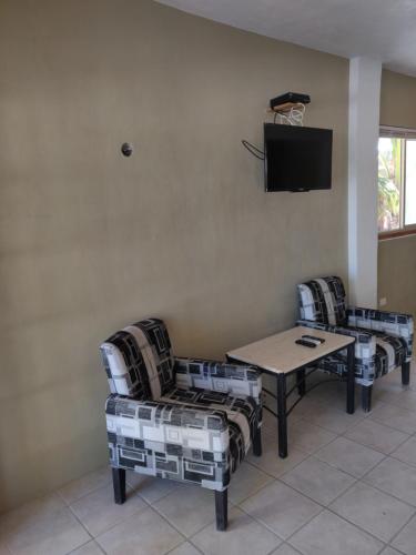 a living room with couches and a table and a tv at Villas Del Mar in Celestún