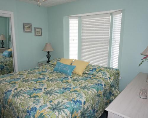 a bedroom with a bed with a pillow on it at Venture Out 402 North Marlin Dr WITH GOLF CART in Panama City Beach