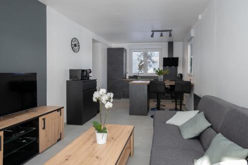 un salon avec un canapé et une table dans l'établissement Chalet les Iris, à Le Massot