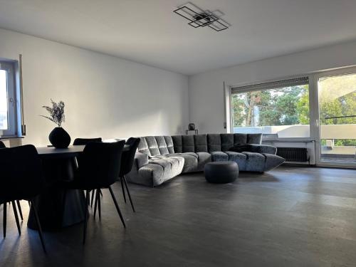 sala de estar con sofá, mesa y sillas en Space Night Apartment, en Bad Bergzabern