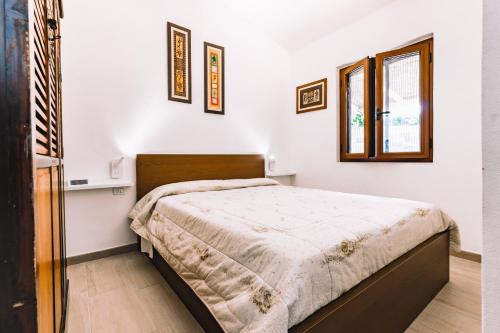een slaapkamer met een bed en 2 ramen bij Villetta Crima Geremeas in Marongiu