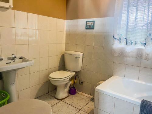 a bathroom with a toilet and a sink and a tub at Leribisi Lodge in Tierpoort