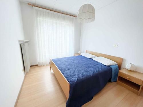 Appartamento Bresimo في Bresimo: غرفة نوم بسرير ازرق في غرفة بيضاء
