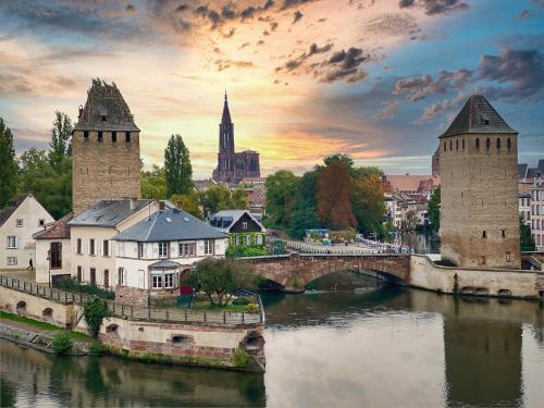 uma cidade com uma ponte e um rio com edifícios em Studios de la Nuée Bleue em Estrasburgo