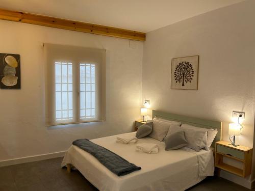 1 dormitorio con 1 cama con 2 mesitas de noche y una ventana en Apartamentos El Búho, en Belmonte