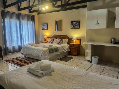 a large bedroom with two beds and a kitchen at Leribisi Lodge in Tierpoort