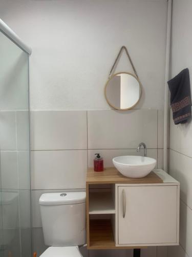 a bathroom with a sink and a toilet and a mirror at Casa na Quadra do Mar Praia Brava in Balneário Camboriú