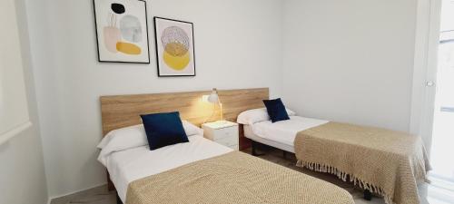2 bedden in een kamer met 2 bedden, waarvan 1 tweepersoonsbed en 1 eenpersoonsbed. bij Amanecer 7 Alicante in Orihuela