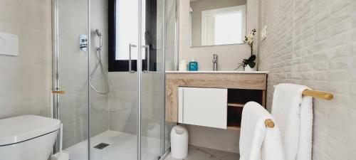een badkamer met een douche, een toilet en een wastafel bij Amanecer 7 Alicante in Orihuela