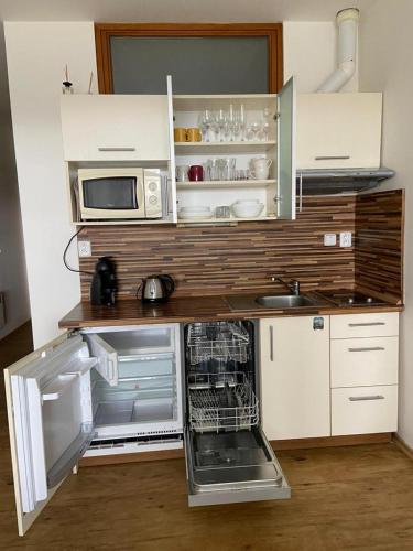 a kitchen with an open refrigerator and a microwave at Lipno Klidné centrum in Lipno nad Vltavou