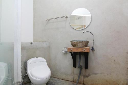 a bathroom with a toilet and a sink with a mirror at NeoMoritz Homestay in Bandung