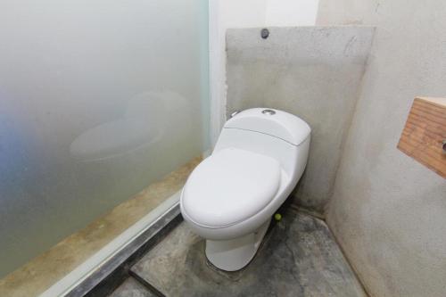 a bathroom with a white toilet in a corner at NeoMoritz Homestay in Bandung