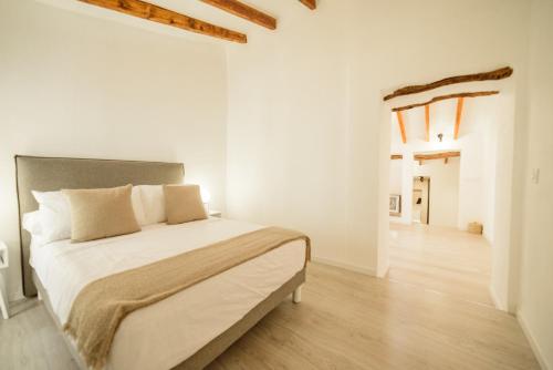 貝尼塔切利的住宿－Mirasol，一间白色卧室,配有一张大床和一个走廊