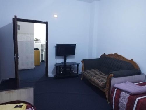 ein Wohnzimmer mit einem Sofa und einem TV in der Unterkunft City Center in Gerasa