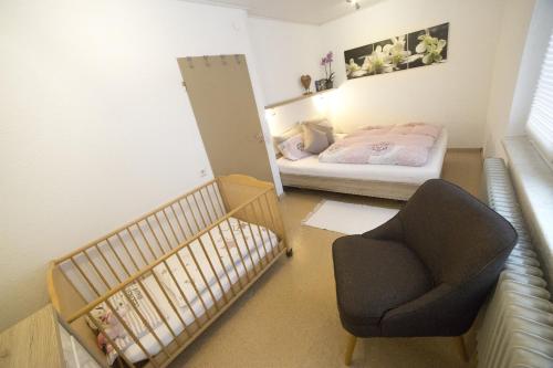 ein kleines Zimmer mit einem Kinderbett und einem Stuhl in der Unterkunft Ferienwohnung Naturpur in Rheinau