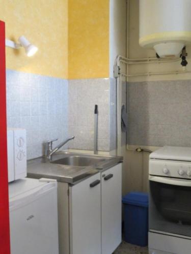 une petite cuisine avec un évier et une cuisinière dans l'établissement Grand Studio accès direct plage - 4CALYP1/4 Large Flat close by sea, à Canet