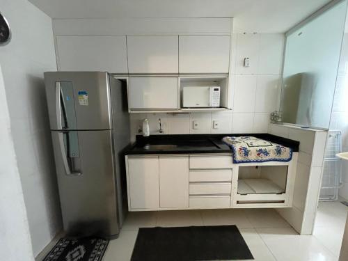 a kitchen with white cabinets and a stainless steel refrigerator at Água Campos in Campos dos Goytacazes
