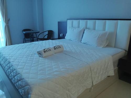 a bedroom with a bed with two pillows on it at Formosa Spacious Apartments with Netflix & Pick Up Service by MESA in Nagoya