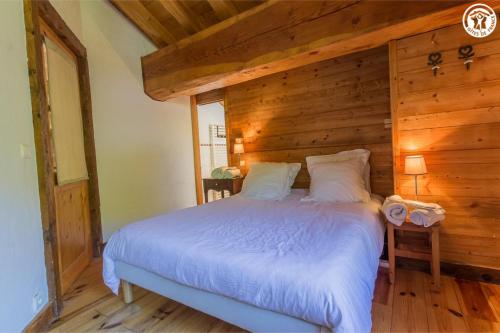 a bedroom with a bed with a wooden wall at Chalet Duhoux in Les Allues
