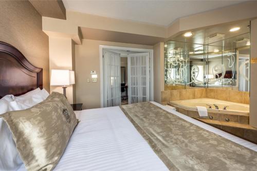 a bedroom with a bed and a bath tub at Monte Carlo Inn & Suites Downtown Markham in Markham