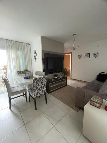 uma sala de estar com um sofá e uma mesa em O seu apê na praia, 2 dormitórios, com piscina em Barra Velha