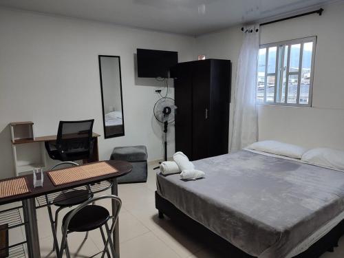 a bedroom with a bed and a desk and a table and chairs at GURUS FR | Cómodo Edificio Casa Confort en Providencia in Pereira