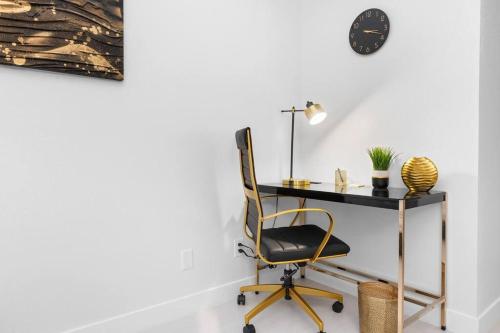 a desk with a chair and a clock on a wall at The Hidden Gem, King bed & Swimming Pool! in Chandler