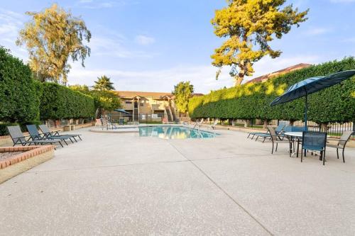 a patio with chairs and an umbrella and a pool at The Hidden Gem, King bed & Swimming Pool! in Chandler