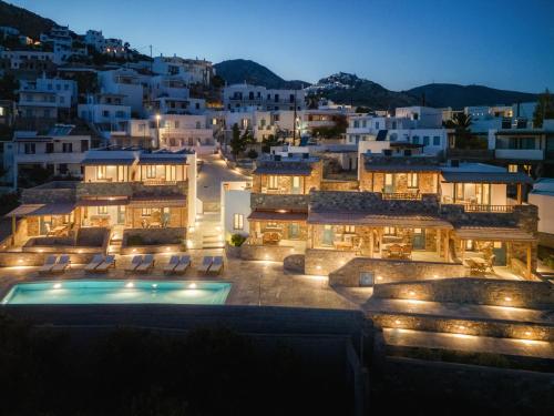 - une vue sur un bâtiment avec piscine la nuit dans l'établissement Galazio Suites, Serifos, à Livadakia