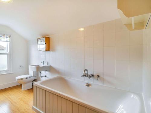 a white bathroom with a tub and a toilet at 4 Bed in Holt 87148 in Holt