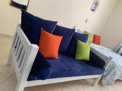 Un sofá azul con almohadas coloridas. en Cozy Nyumbani Studio Apartment In Mtwapa ., en Mtwapa