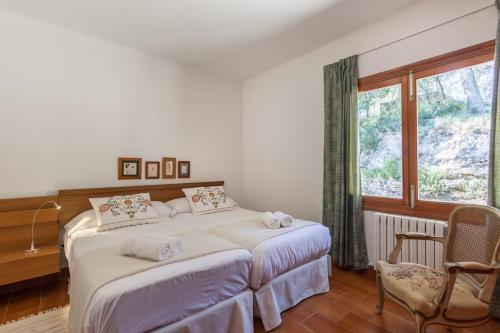 ein Schlafzimmer mit einem großen Bett und einem Fenster in der Unterkunft Es Puig de Ses Coves in Santa Eugènia