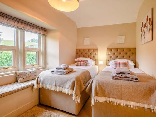 two beds in a room with two windows at 4 Bed in Ullswater 88023 in Dockray