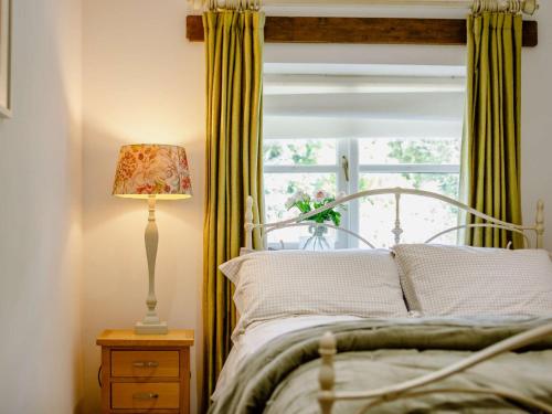 1 dormitorio con 1 cama con lámpara y ventana en 1 Bed in Marazion 88008, en Ludgvan